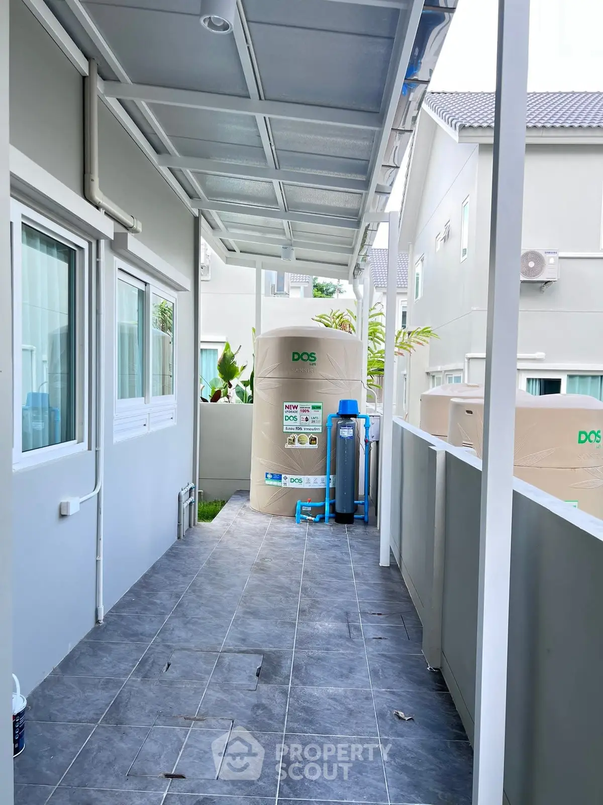 Modern exterior with water tank and tiled walkway in residential property