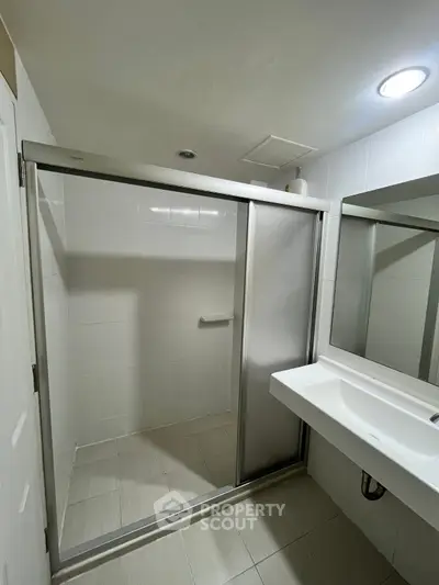 Modern bathroom with sleek shower enclosure and contemporary sink design.
