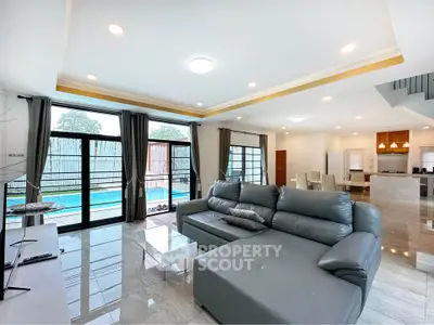 Spacious modern living room with pool view and open kitchen layout