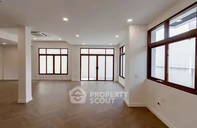 Spacious modern living room with large windows and wooden flooring
