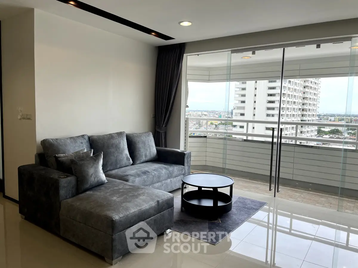 Modern living room with sleek sofa and balcony view in high-rise apartment