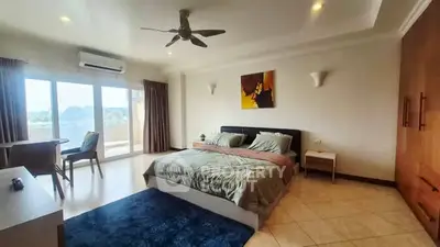 Spacious bedroom with modern decor and balcony access in a luxurious apartment.