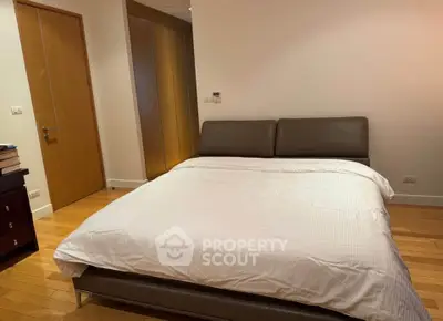 Spacious bedroom with modern design and wooden flooring in a luxury apartment.