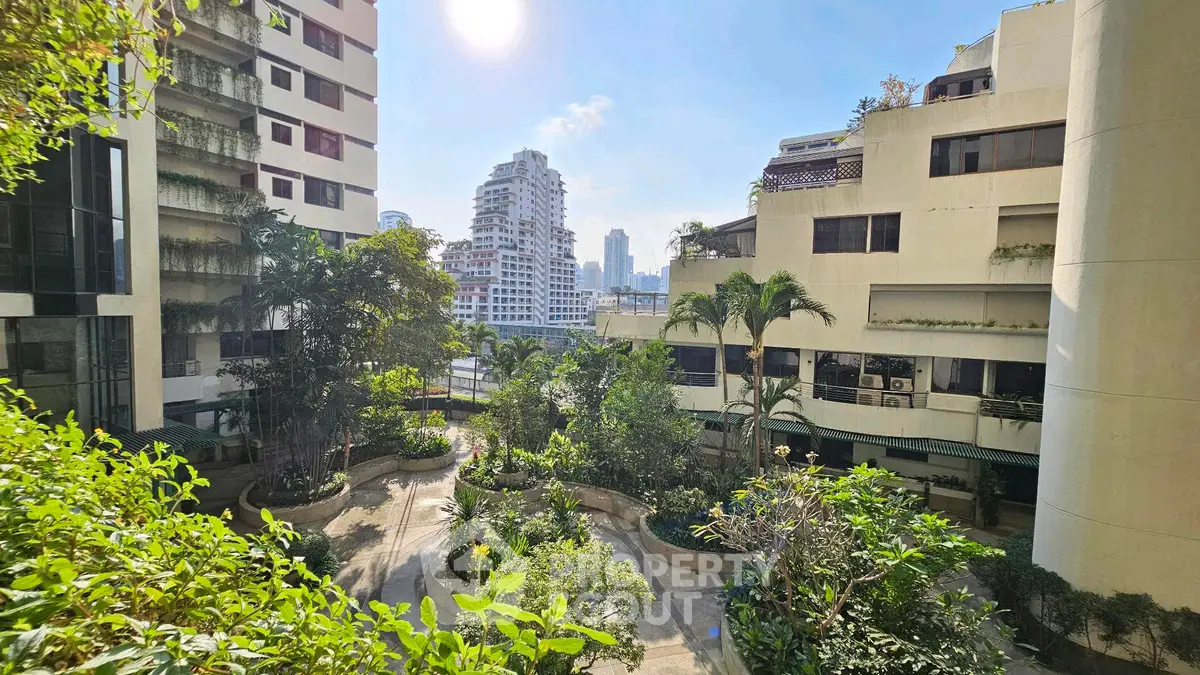 Stunning urban garden view from a high-rise building balcony, showcasing lush greenery and city skyline.