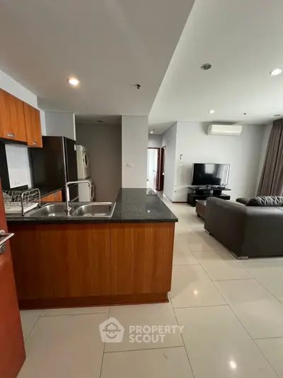 Modern open-plan kitchen and living room with sleek design and ample natural light.