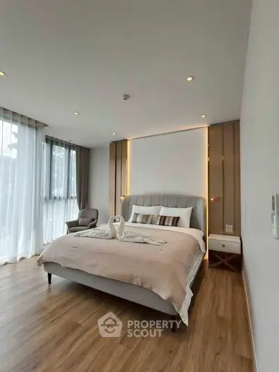 Modern bedroom with elegant decor and large windows for natural light