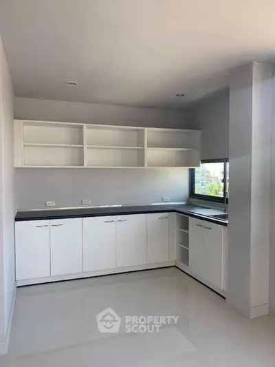 Modern kitchen with sleek white cabinetry and ample natural light