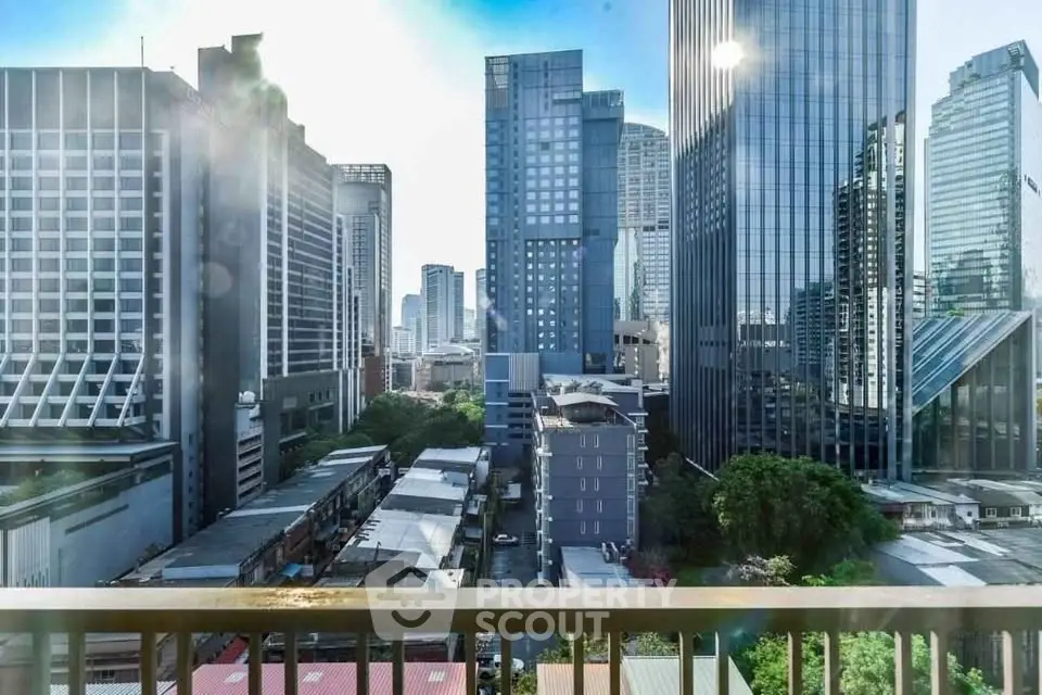 Stunning cityscape view from a high-rise balcony overlooking modern skyscrapers and urban landscape.