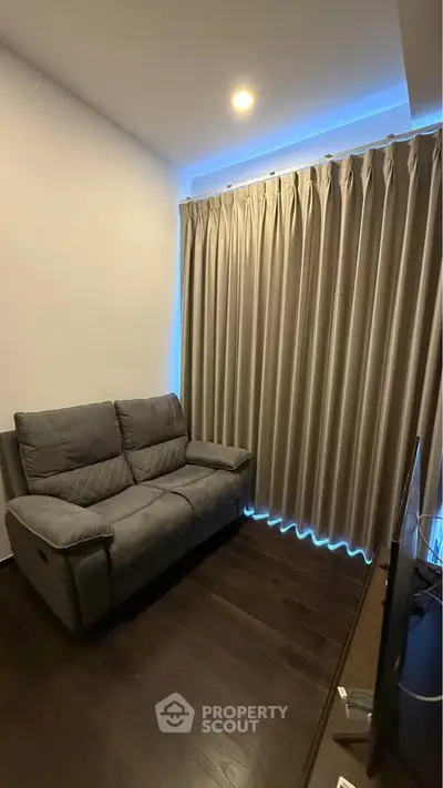 Cozy living room with modern sofa and elegant curtains, perfect for relaxation.