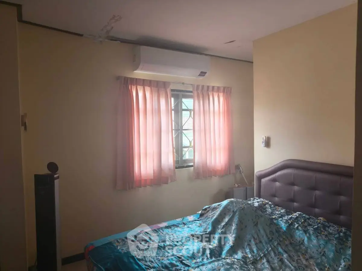 Cozy bedroom with air conditioning and soft pink curtains, perfect for relaxation.