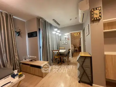 Modern living room with stylish decor and dining area, featuring elegant lighting and wooden flooring.
