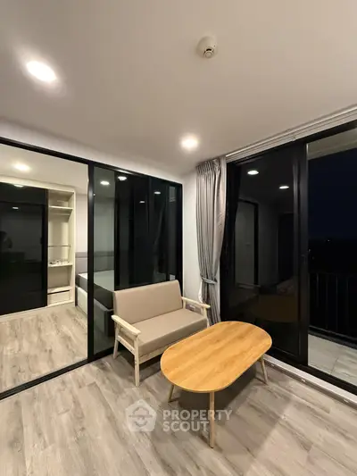 Modern living room with sleek glass doors and cozy seating area, perfect for relaxation and entertaining.