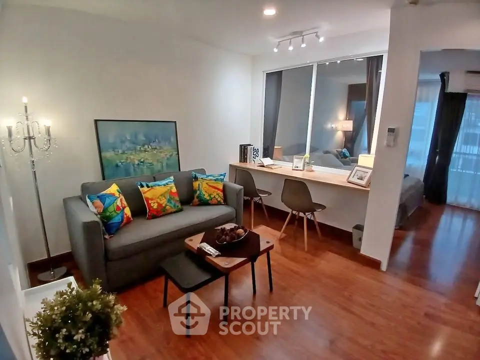 Stylish living room with colorful cushions and modern decor in a cozy apartment setting.