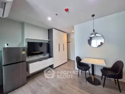 Modern living room with sleek furniture and dining area in a stylish apartment.