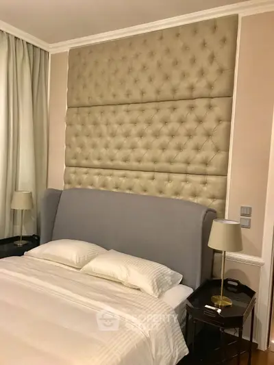Luxurious bedroom with elegant tufted headboard and modern bedside lamps.