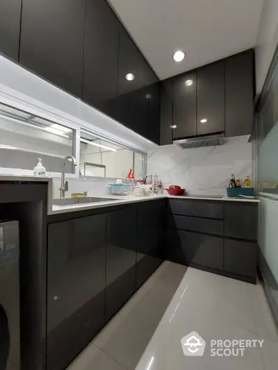 Modern kitchen with sleek black cabinets and glossy white countertops