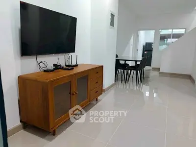 Modern living room with sleek TV setup and elegant dining area, perfect for contemporary living.