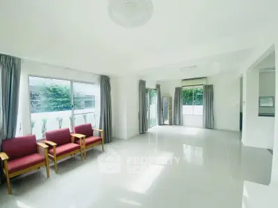 Spacious and bright living room with large windows and elegant decor