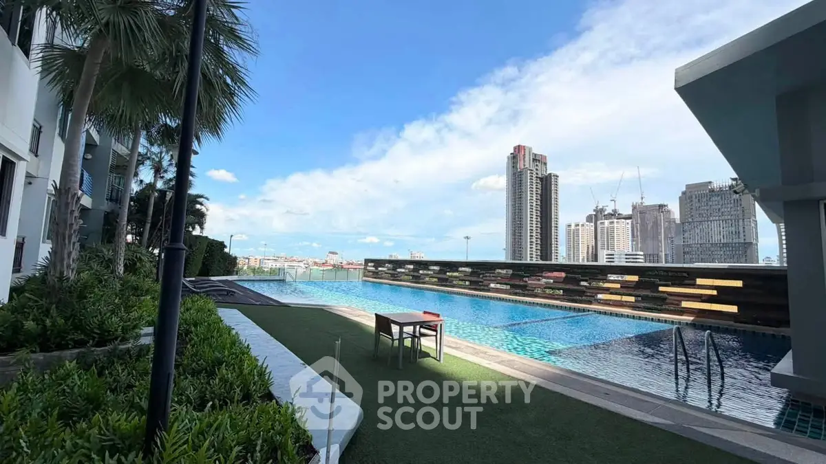 Luxurious rooftop pool with stunning city skyline views in modern high-rise building.