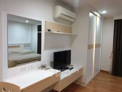 Modern bedroom with sleek design, featuring built-in wardrobe, wall-mounted TV, and air conditioning.