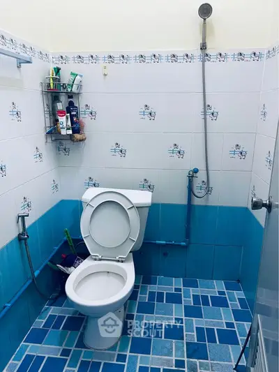 Cozy bathroom with blue tile accents and modern shower setup.