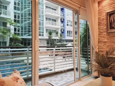 Luxurious condo with pool view from spacious balcony, featuring modern glass doors and elegant interior design.