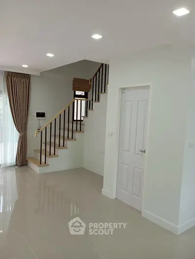 Modern interior with staircase and elegant curtains in a bright living space.