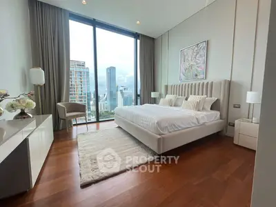 Luxurious bedroom with stunning city view, featuring elegant decor and floor-to-ceiling windows.