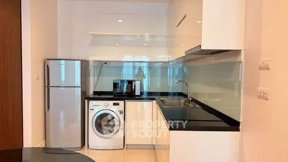 Modern kitchen with sleek appliances and glossy cabinetry in a stylish apartment.
