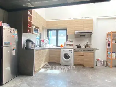Modern kitchen with washing machine and sleek wooden cabinets