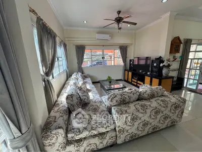 Spacious living room with elegant floral sofa and modern entertainment center