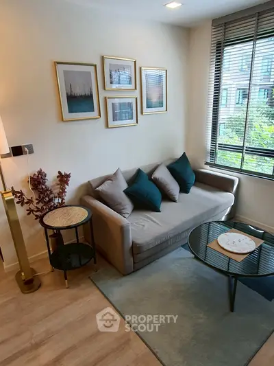 Stylish living room with modern decor, cozy sofa, and large window view.