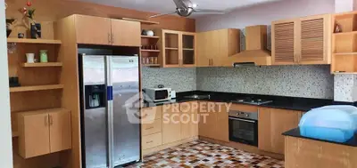 Spacious kitchen with modern appliances and wooden cabinetry