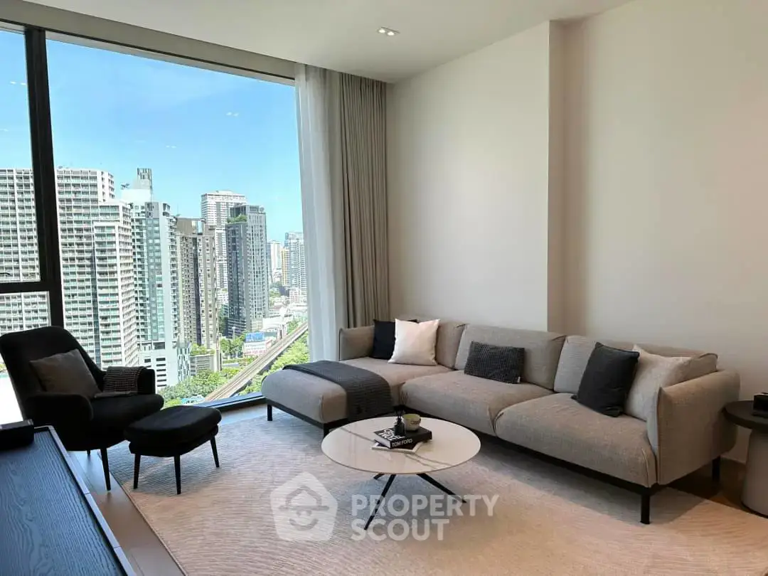 Modern living room with panoramic city view, featuring sleek furniture and large windows in a high-rise apartment.