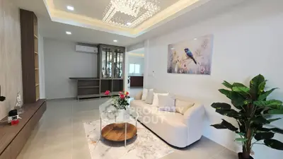 Elegant living room with modern decor, featuring a cozy sofa, glass coffee table, and stylish lighting.