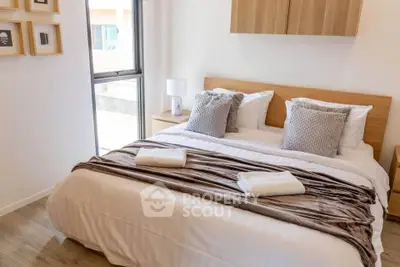 Cozy bedroom with modern decor and natural light, featuring a comfortable bed and stylish furnishings.