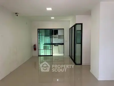 Spacious modern apartment with sleek glass doors and open kitchen layout.