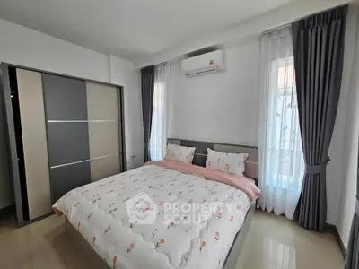 Spacious bedroom with modern decor and ample natural light, featuring a large bed and stylish curtains.