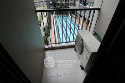 Compact balcony with pool view in modern apartment complex
