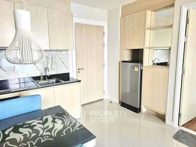 Modern kitchen with sleek cabinetry and compact fridge in a stylish apartment