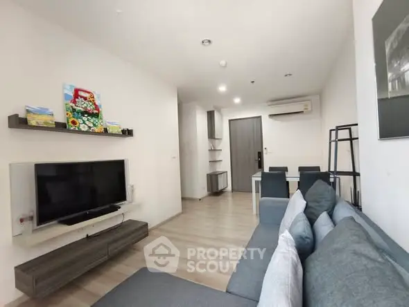 Modern living room with sleek furniture and wall-mounted TV in a stylish apartment.