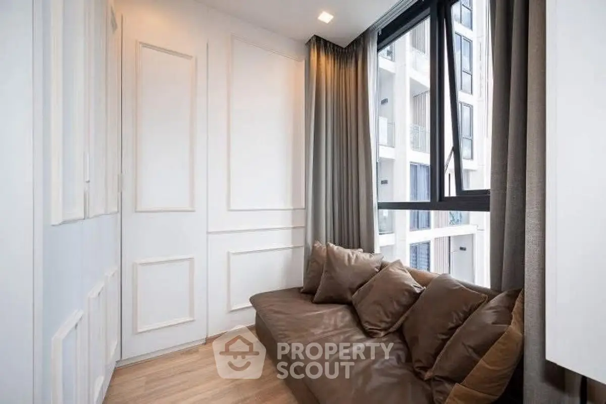 Modern cozy corner with brown sofa and large window in stylish apartment