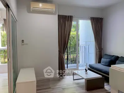 Modern living room with sleek design, featuring a cozy sofa, air conditioning, and a view of the balcony.