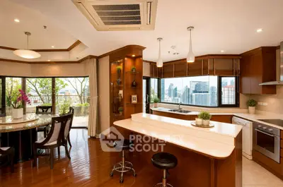Luxurious open-plan kitchen and dining area with city view and balcony access.
