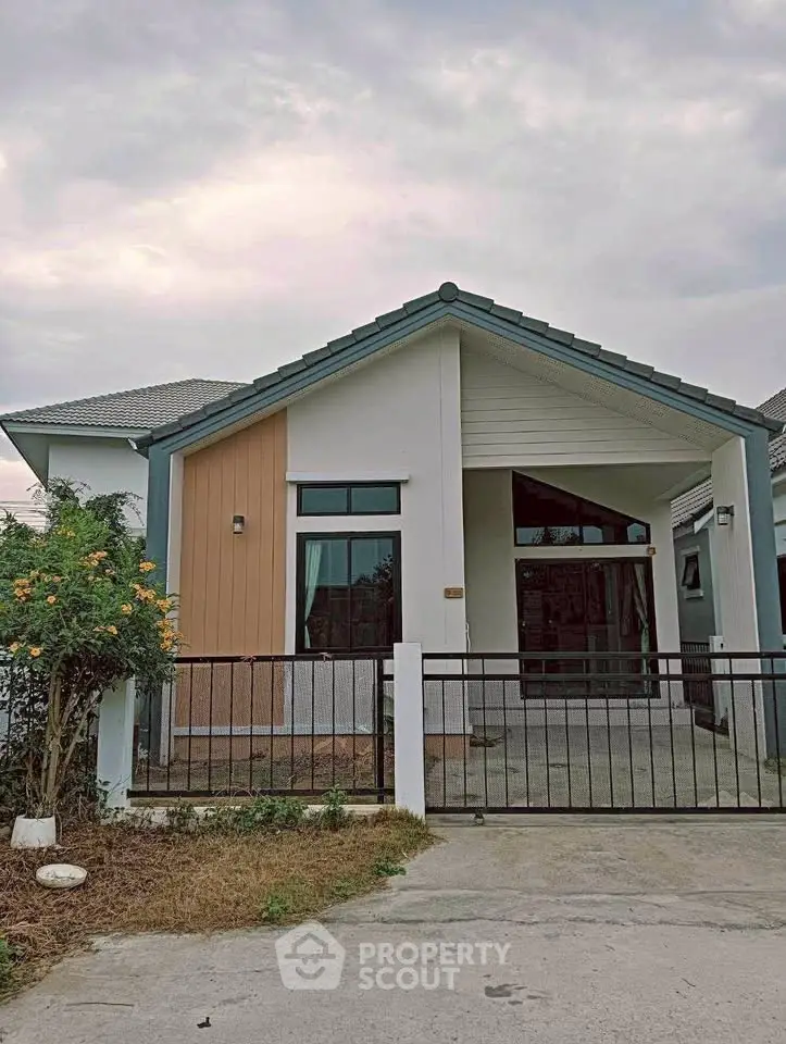 Charming single-story house with modern facade and gated entrance, perfect for family living.