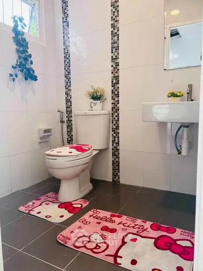 Charming bathroom with Hello Kitty decor, featuring modern fixtures and stylish tile accents.