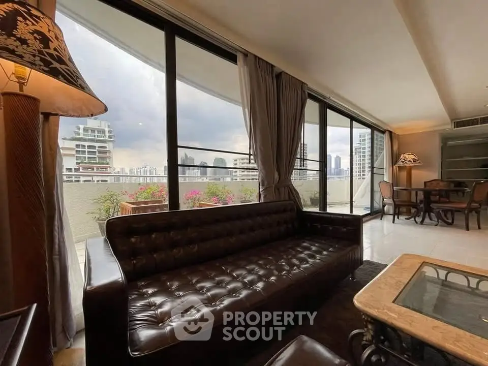 Spacious living room with panoramic city view and elegant leather sofa