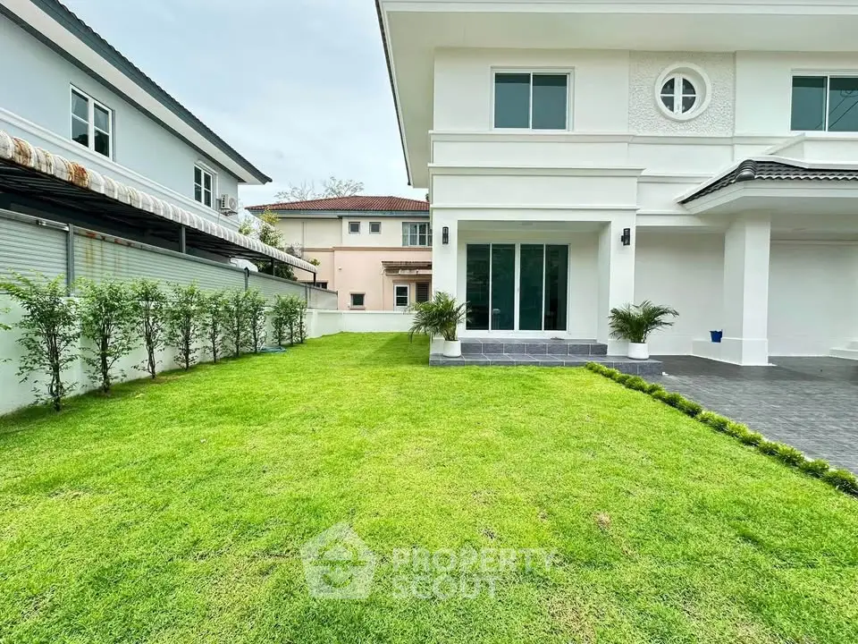 Spacious modern house with lush green lawn and elegant exterior design.