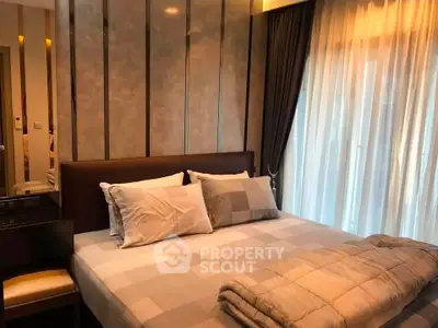 Luxurious bedroom with elegant decor and large window for natural light.