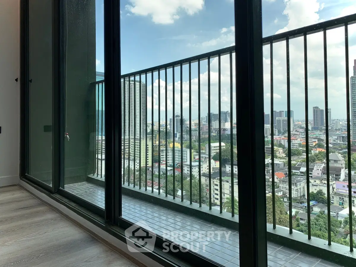 Stunning city view from a high-rise balcony with sleek glass railing and modern flooring.